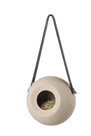 Det hvide keramik fuglefoderhus hængt op i en sort gummirem fra Garden Life med foder i. 