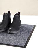 Sort, dørmåtte fra Day med sko ovenpå 