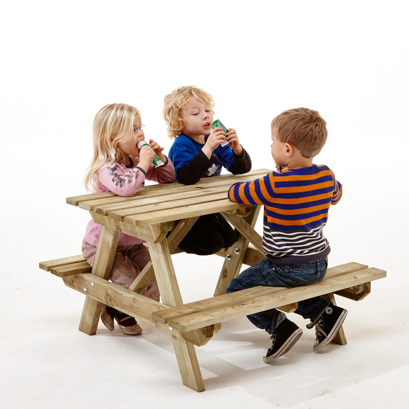 Tre børn der sidder ved et bord og bænkesæt lavet i trykimprægneret fra Nordic Play 