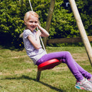 En pige sidder og gynger på den røde tallerkengynge fra Nordic Play 