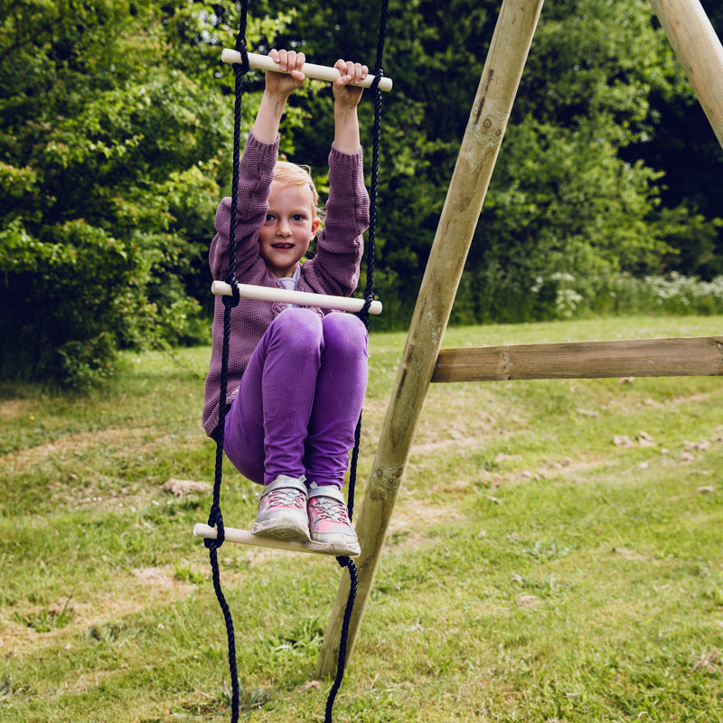 En pige der hænger og leger på 5 trins rebstigen fra Nordic play 