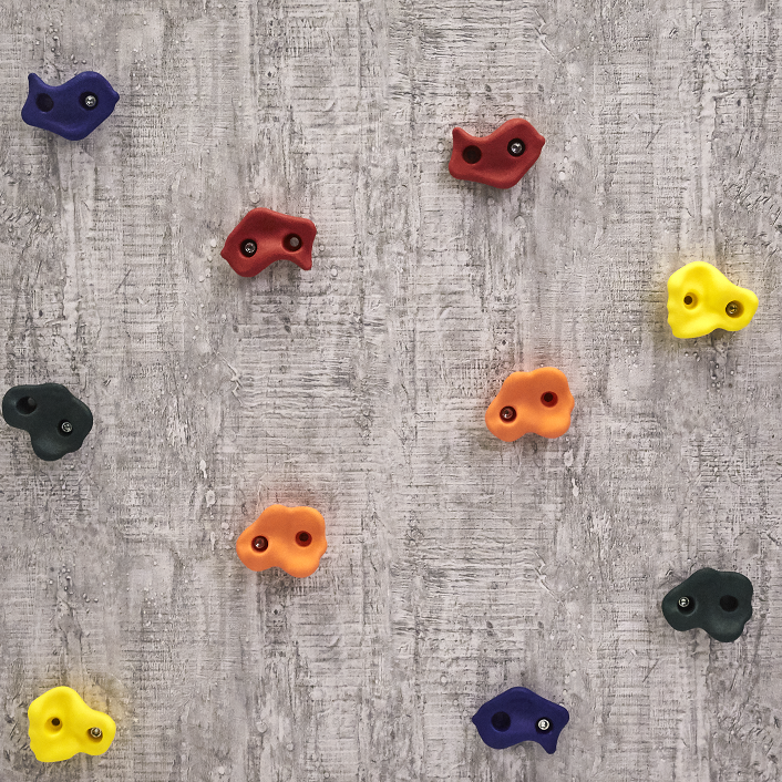 Der er mange af de farverige klatresten fra Nordic Play der er skruet ind i en væg