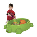 Grøn skildpadde sandkasse i plast med låg fra Paradiso Toys, med en dreng der leger i den