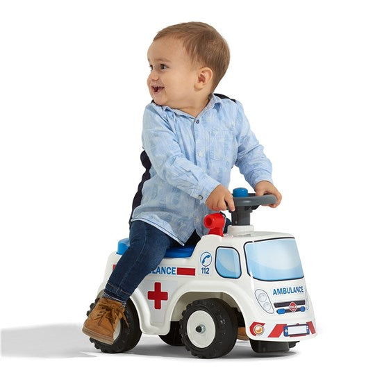 En dreng der leger på ride-on ambulancen fra falk