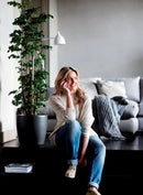 En kvinde der sidder ved siden af den sorte Brussels Round urtepottesjuler fra Elho