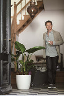 En mand går ved siden af en grøn plante med en Elho fereivander i 